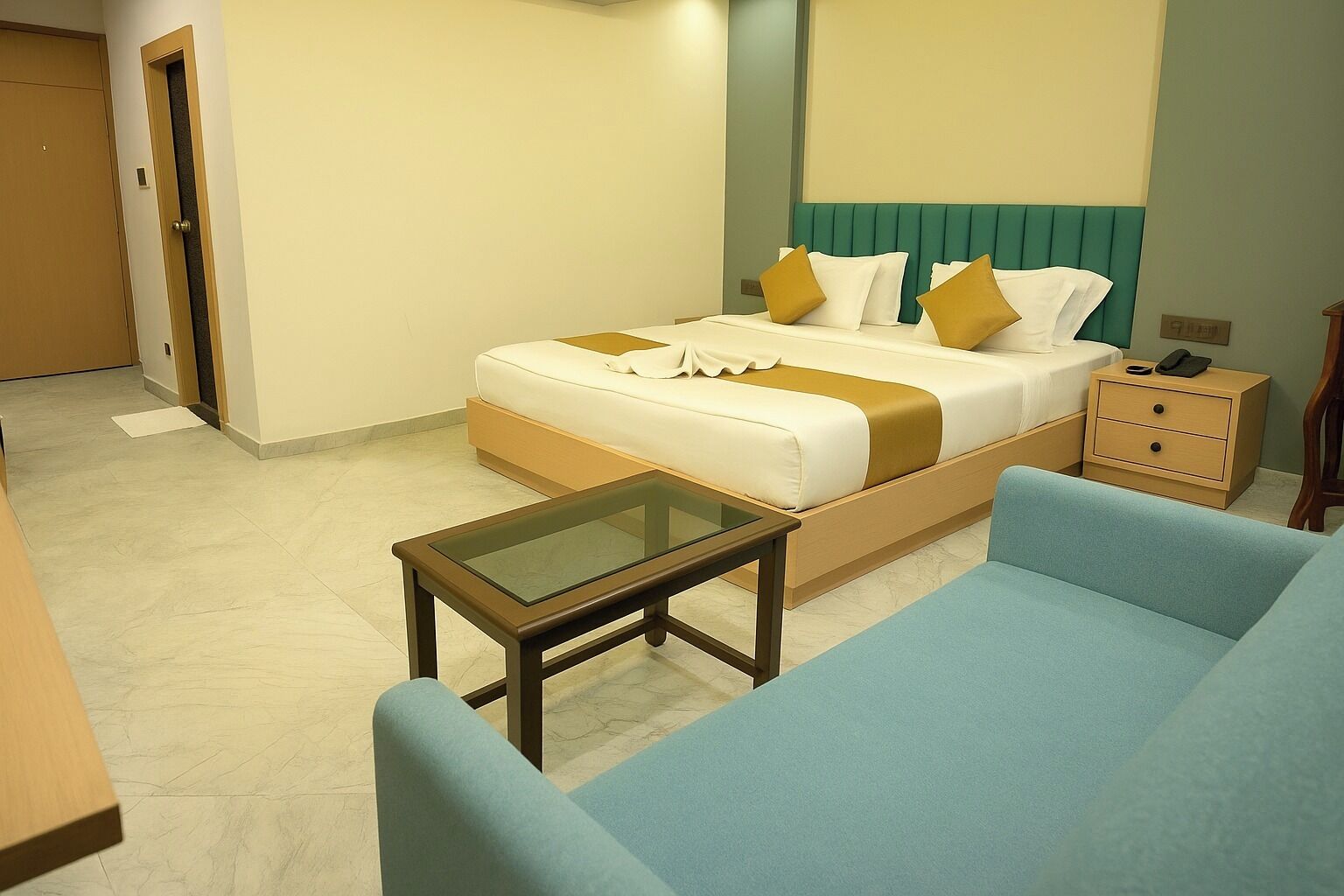 Habitació d'hotel amb llit, una taula de nit, una cadira i un descobert.