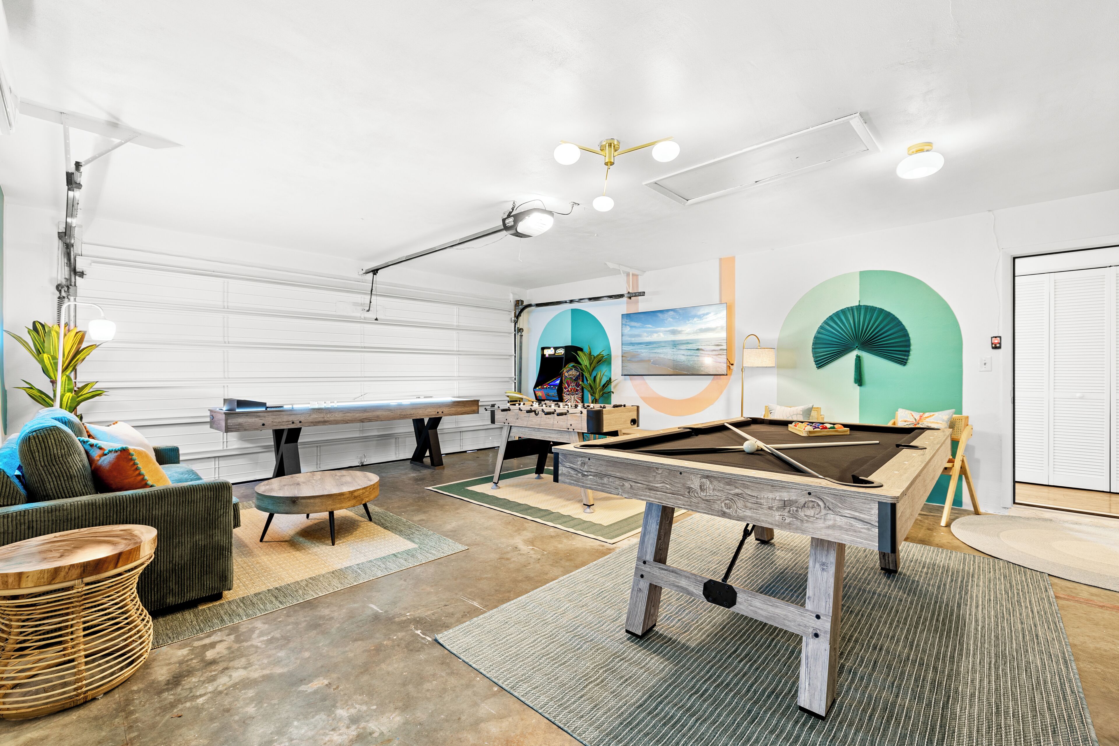 Un salón recreativo con mesa de billar, mesa de fútbol de mesa y asientos cómodos.
