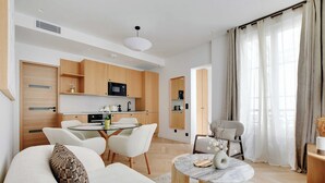 Ein modernes Wohnzimmer mit einer Couch, einem Couchtisch und einem Essbereich mit Stühlen.