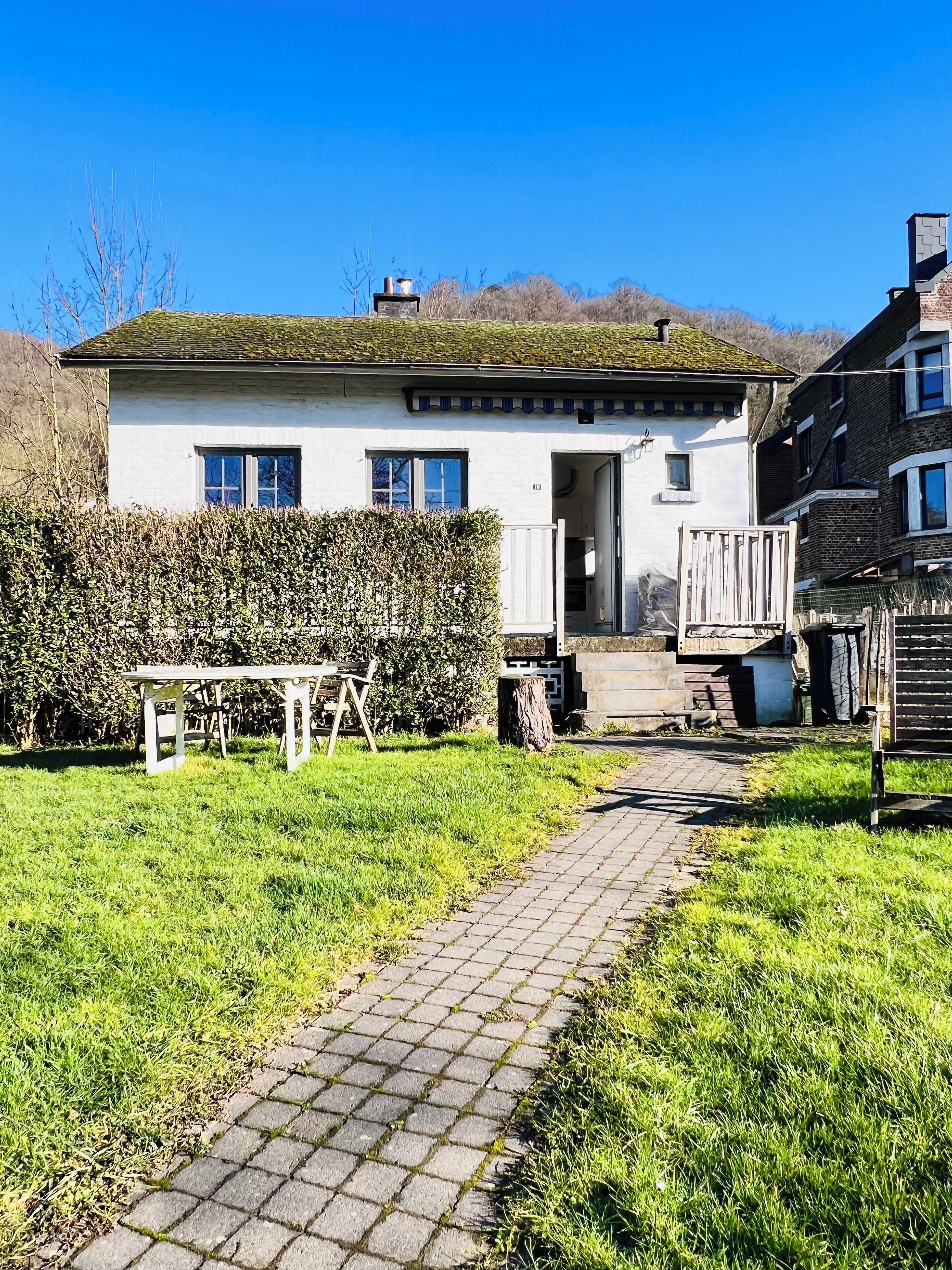 Una casa bianca con un vialetto lastricato che conduce all'ingresso.