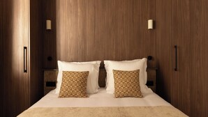 Un dormitorio con una cama grande, armario de madera y mesita de noche.