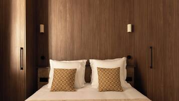 Un dormitorio con una cama grande, armario de madera y mesita de noche.