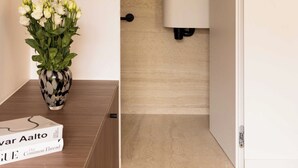 Un baño moderno con un mueble de tocador de madera, un lavabo blanco y un espejo.