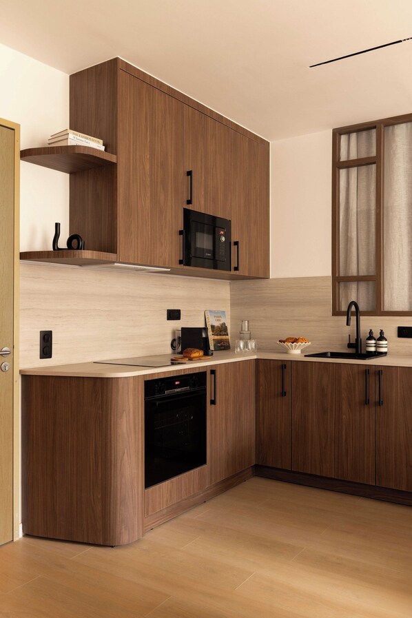 A modern kitchen with wooden cabinets, a built-in microwave, a dishwasher, and a sink.
