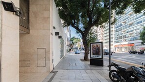 A sidewalk with a tiled pattern, a tree, and a parked motorcycle. - MOT Libertador 5700 (Buenos Aires)