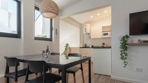A modern kitchen with white cabinets, a microwave, and a coffee machine. - MOT Libertador 6300 (Buenos Aires)