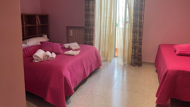 A hotel room with two beds, a wardrobe, an air conditioner, and a view through sheer curtains. - RoMi's House cozy facility in the hills of the Castelli Romani. (Lazio)