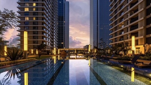 A modern hotel with a central swimming pool, surrounded by high-rise buildings and well-lit pathways. - 2BR Apartment in Westlands,Nairobi|GTC|13th Floor (Nairobi)