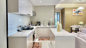 A modern kitchen with a central island, stainless steel appliances, and a minimalist design. - 2BR Apartment in Westlands,Nairobi|GTC|13th Floor (Nairobi)