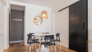 A dining area with a round table, black chairs, and two hanging pendant lights. - MOT Anchorena 1400 (Buenos Aires)