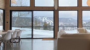 A modern interior with large windows offering a snowy mountain view. - Harfång - Spectacular view of Mount Edward (L'Anse-Saint-Jean)