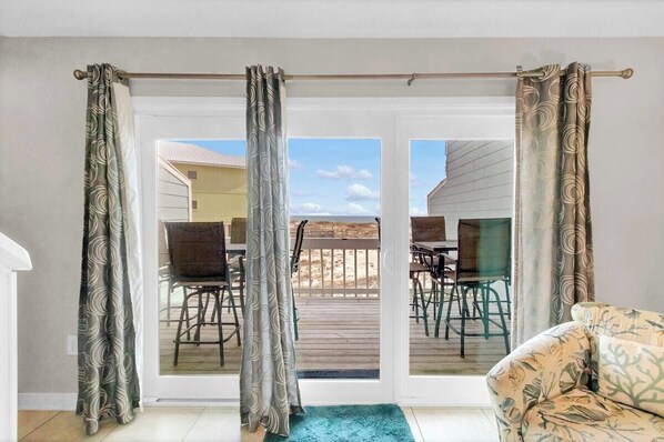 A room with a sliding glass door leading to an outdoor patio with a table and chairs.