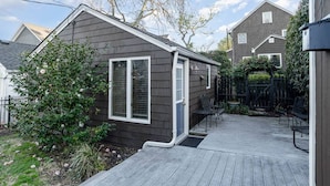 Une petite maison avec une terrasse, une fenêtre et une porte.