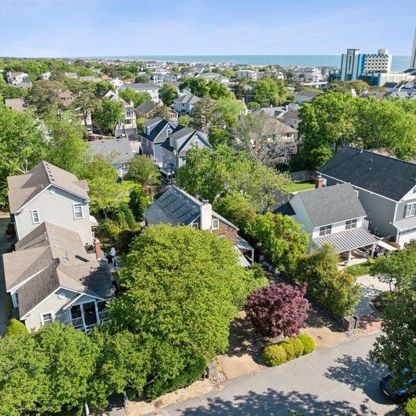 Un quartier résidentiel avec des maisons, des arbres et une vue sur l’océan.