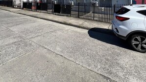 A row of red houses with a white car parked in front. - departamentos egaña (Puerto Montt)