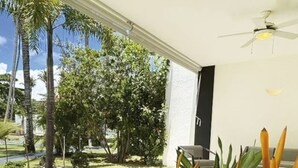 A room with a view of a garden, a ceiling fan, and a chair. - Aligio - A Quiet Retreat in Paradise - 2 BR, 2 pools, WiFi, AC, Private Hot Tub (Las Terrenas)