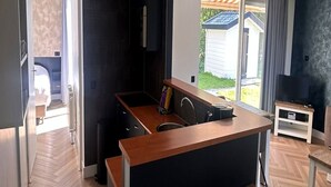 Una cocina moderna con una isla central, un horno empotrado y un ventanal con vistas al exterior.