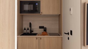 A compact kitchen with a microwave, sink, and wooden cabinets. - Charming Studio With AC - 2P- Musee du Louvre (Paris)