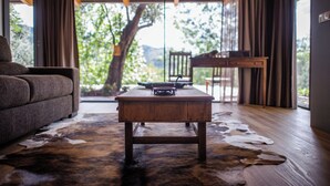 Una sala de estar con un sofá, una mesa de centro de madera y un tapiz de cuero de vaca.