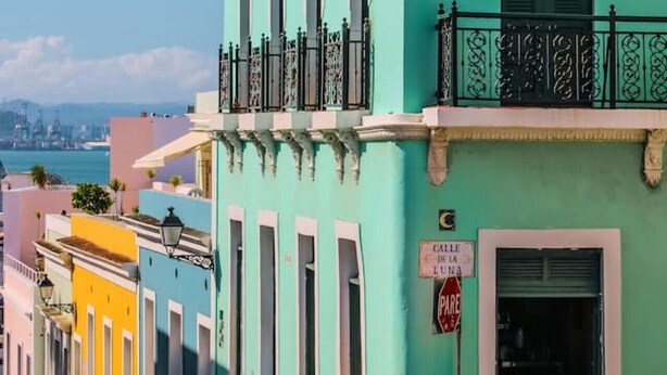 A turquoise building with a balcony and a flag. - Ocean Sol Historic Old San Juan (San Juan)
