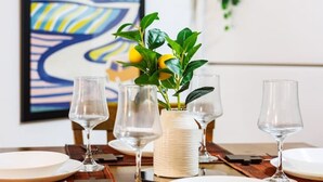 A dining table set with plates, glasses, and a vase with a plant. - Ocean Sol Historic Old San Juan (San Juan)