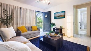 A modern living room with a sofa, coffee table, and a ceiling fan. - Ocean Sol Historic Old San Juan (San Juan)