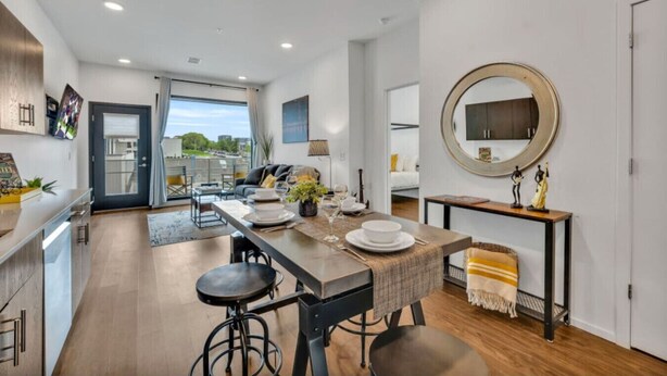 Una cocina moderna con comedor, que cuenta con un amplio ventanal, un espejo redondo y vistas al exterior.