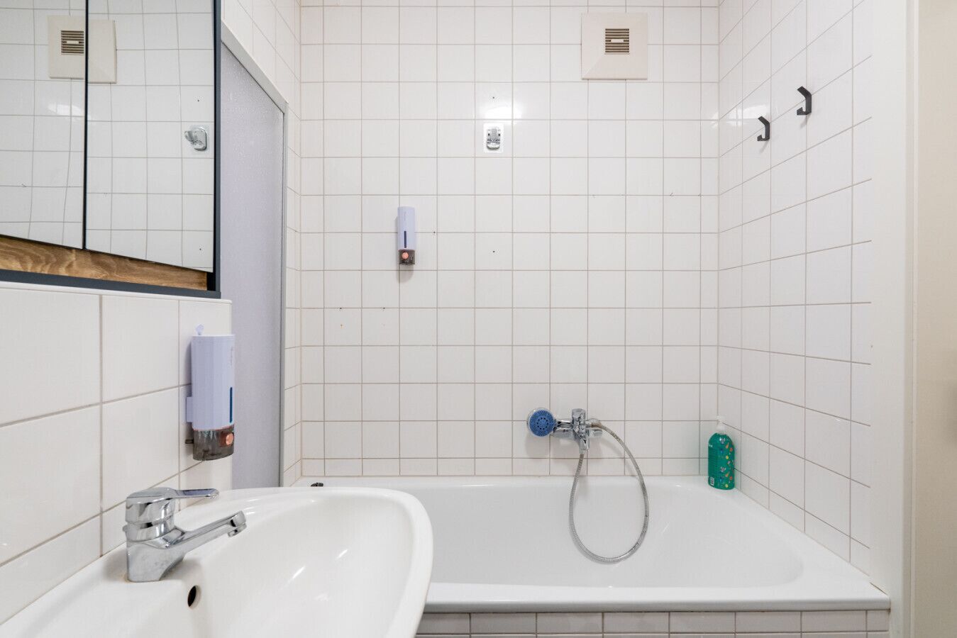 Een badkamer met een wastafel, een bad en een douche.