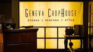 Zona de recepción con un letrero del Geneva ChopHouse, destacando carnes, mariscos y estilo.