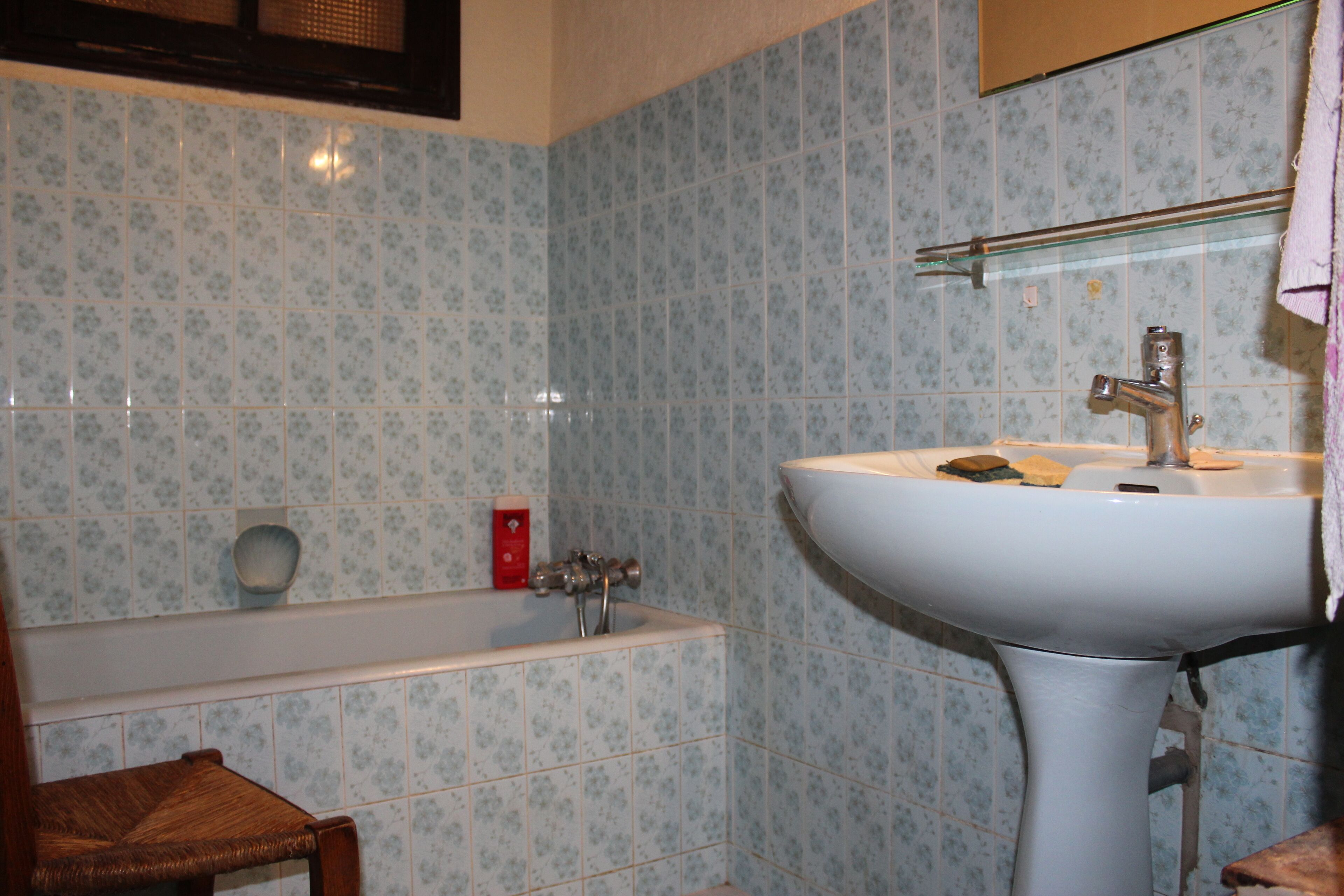 Une salle de bain avec une baignoire, un lavabo et un miroir.