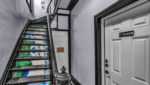 A staircase with a sign indicating a laundry room, a door labeled "1st Floor," and a decorative metal railing. - Spacious 6-bedroom house with WiFi, AC  and free Parking in brilliant Buffalo (Buffalo)