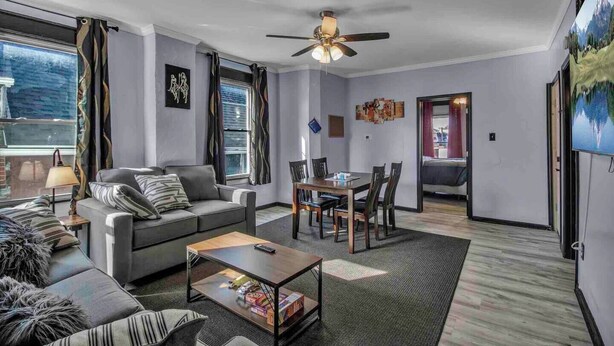 A modern living room with a sofa, coffee table, and dining area. - Spacious 6-bedroom house with WiFi, AC  and free Parking in brilliant Buffalo (Buffalo)