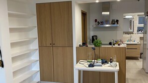 A modern kitchen with a central island, built-in cabinets, and a dining area with a table and chairs. - Renovated apartment, sea view, S-W orientation, terrace, near Monaco, Mala beach (Cap-d'Ail)