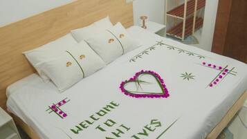 A neatly made bed with a welcome message, a wooden headboard, and a bedside table.