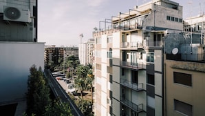 En flervåningsbostadsbyggnad med balkonger, luftkonditioneringsanläggningar och satellitmottagare.