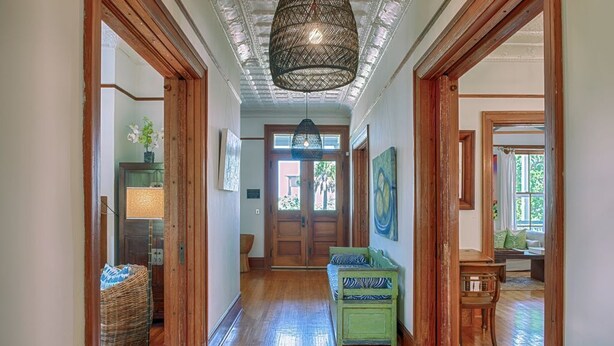 A hallway with wooden floors, a green bench, and a hanging light fixture. - Officers Row - Elegant historic mansion w/pool steps from beach (Tybee Island)