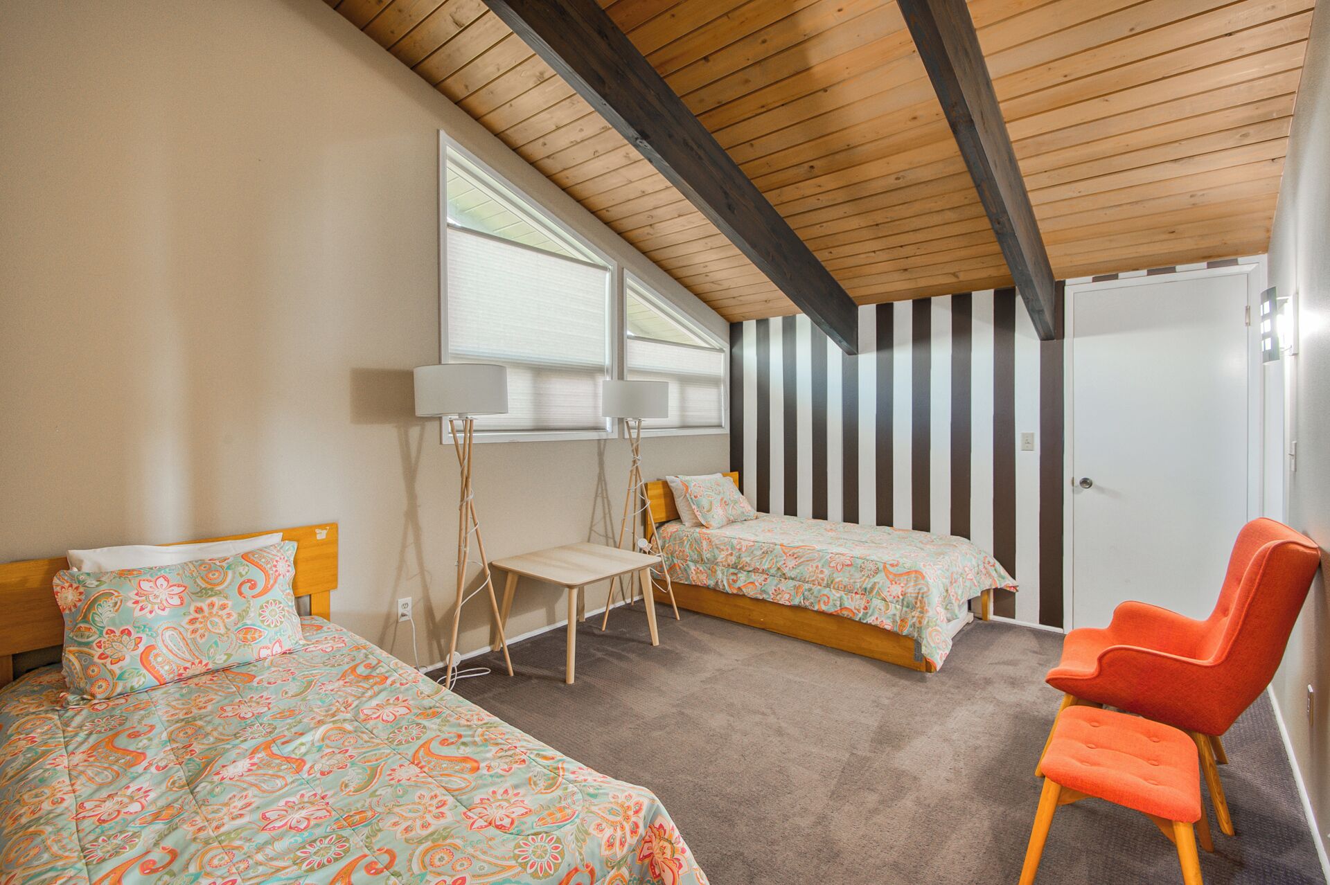 Une chambre avec deux lits, un bureau, une chaise et une armoire.