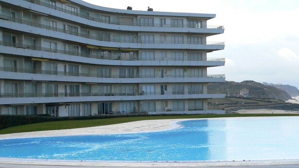 Un hotel de varios pisos con una zona de piscina.