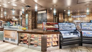 Un comptoir de boulangerie où sont présentés, dans des vitrines, une variété de pains et de pâtisseries.
