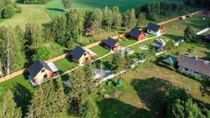 Vue aérienne d’un quartier résidentiel avec de nombreuses maisons, une aire de jeux et, au loin, un terrain de golf.
