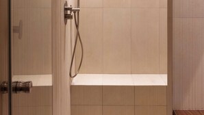 Um banheiro moderno com chuveiro, banheira e vaso sanitário.