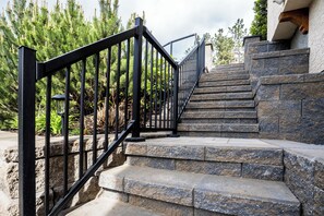 Una escalera de piedra con barandillas de metal negro que conduce a un edificio.