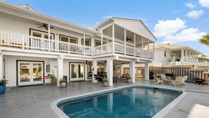 A two-story house with a swimming pool, outdoor furniture, and a covered patio area. - Waterfront Home w/ Private Pool | Key Allegro | 5BR · Sleeps 14 (Rockport)