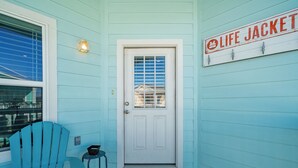 A door with a sign above it reading "LIFE JACKET" and a blue chair to the left. - Coastal Getaway w/ Community Pool + Fishing Nearby (Rockport)