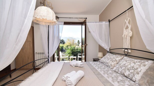 A bedroom with a bed, a sofa, a canopy, and a view of the outdoors. - Villa Carini Holiday House by the Sea and Jacuzzi pool (Carini)