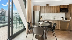 Une cuisine moderne avec des meubles en bois, un réfrigérateur en acier inoxydable et un four à micro-ondes encastré.