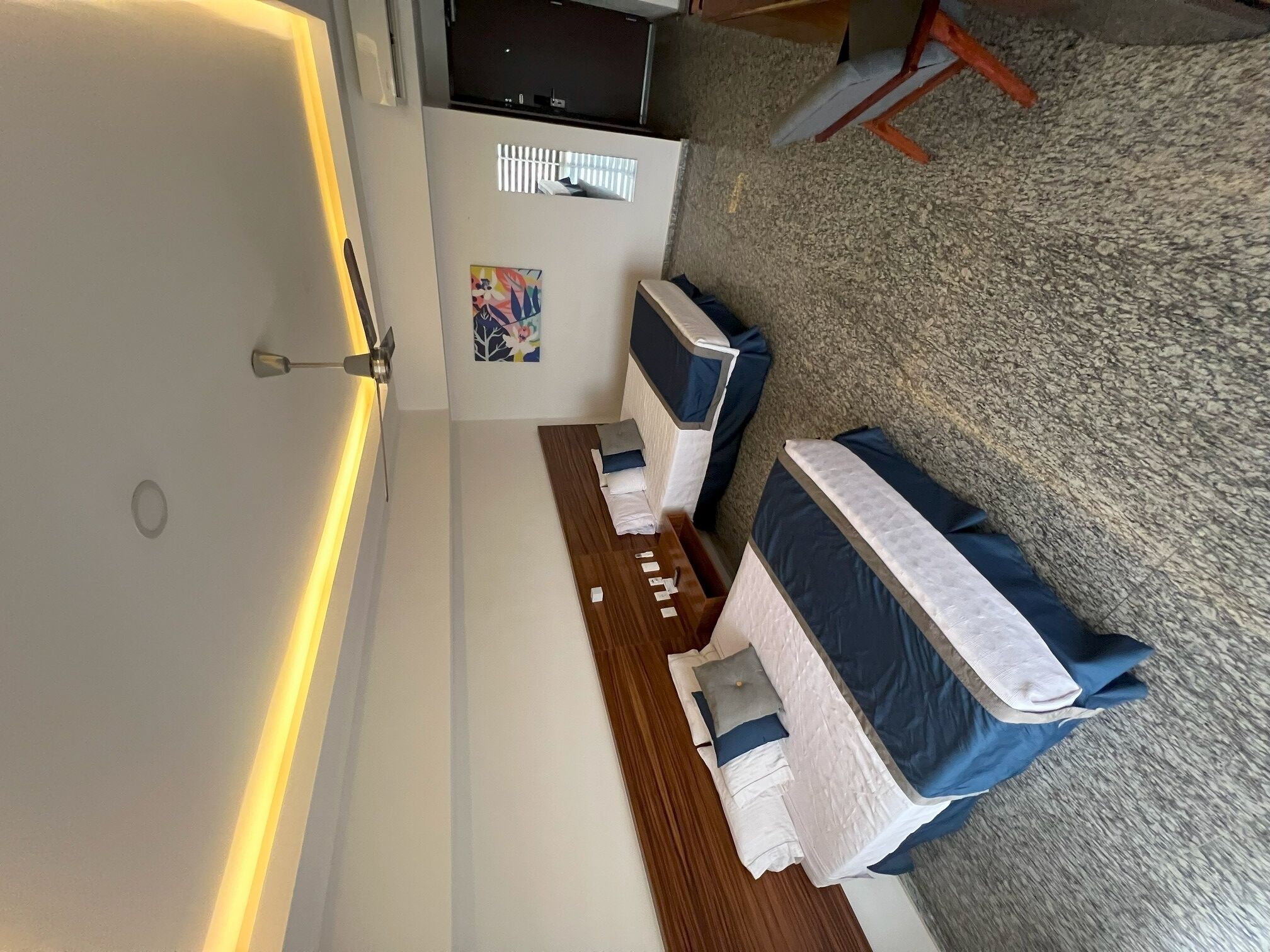 Ein Hotelzimmer mit Bett, Schreibtisch und Stuhl.