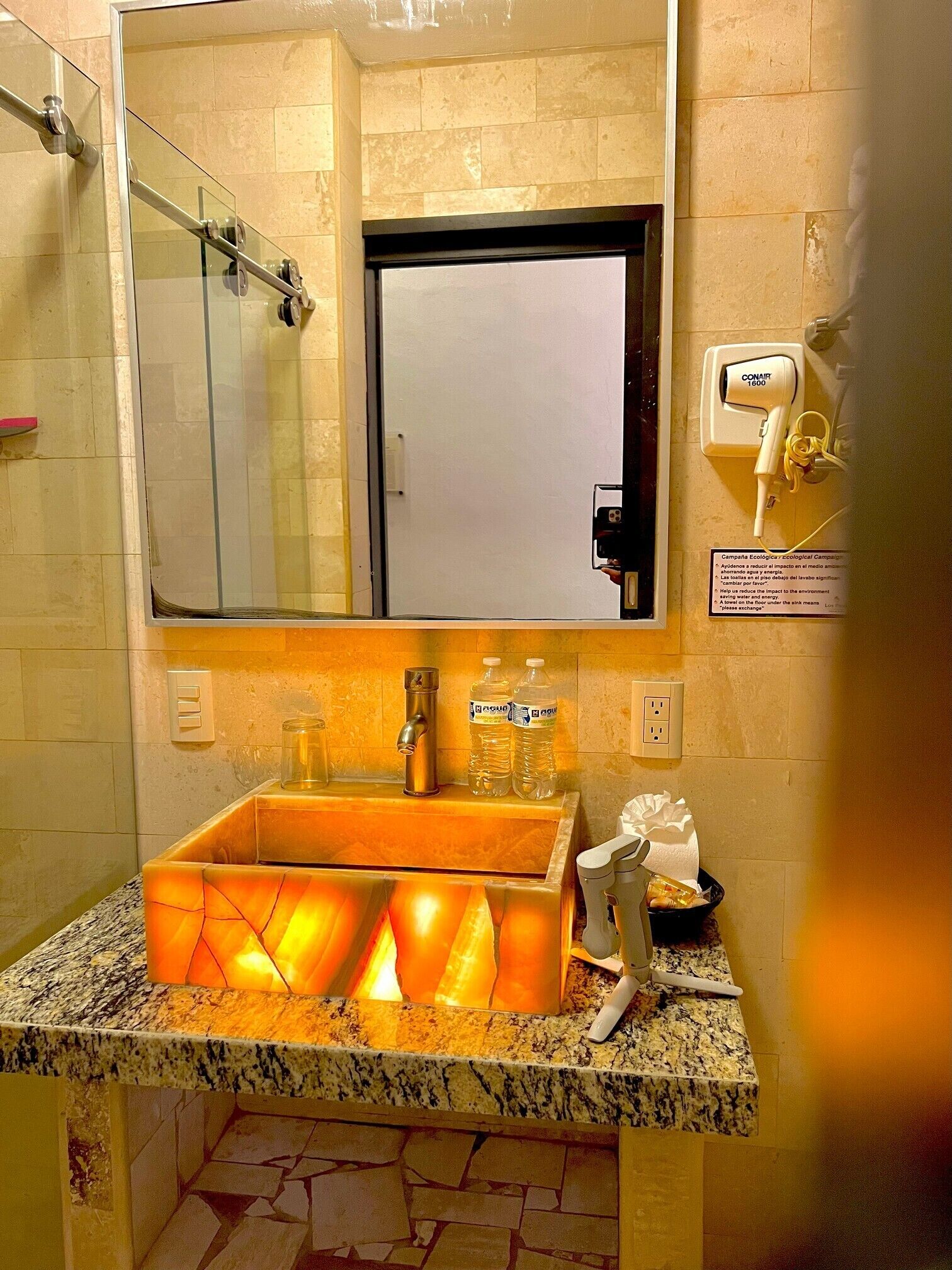A bathroom with a sink, mirror, and shower.
