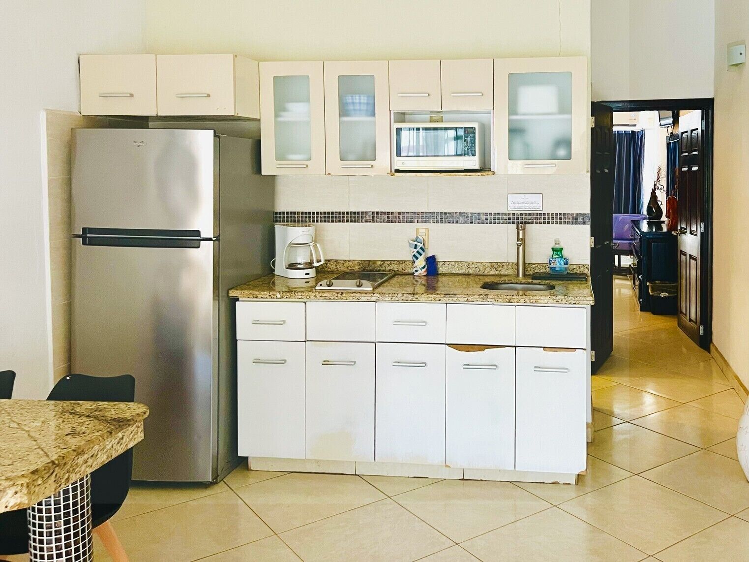 A compact kitchen with a refrigerator, microwave, and coffee maker.