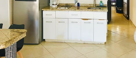 A compact kitchen with a refrigerator, microwave, and coffee maker.